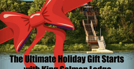 A large red ribbon and bow overlay a photo of King Salmon Lodge on the Naknek River, with stairs leading down to the water and trees surrounding the lodge. Text reads, “The Ultimate Holiday Gift Starts with King Salmon Lodge,” along with the King Salmon Lodge logo.
